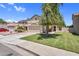 Exterior view of a beige two-story home with well-maintained lawn, complemented by lush greenery and a driveway at 3608 W Harrison St, Chandler, AZ 85226
