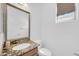 Bright bathroom featuring a granite vanity countertop, a large framed mirror, and natural light at 3745 E Flamingo Way, Gilbert, AZ 85297