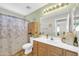 Clean bathroom featuring wood cabinets, a shower with flower curtain, and ample lighting at 3745 E Flamingo Way, Gilbert, AZ 85297