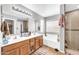 Bathroom featuring a double sink vanity, tub, and glass enclosed shower at 3745 E Flamingo Way, Gilbert, AZ 85297