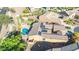 Aerial view showcasing the home's roof with solar panels, alongside a putting green and curved pool at 42318 W Abbey Rd, Maricopa, AZ 85138