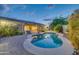 Picturesque backyard with a pool, spa, and well-maintained landscaping and covered patio at 42318 W Abbey Rd, Maricopa, AZ 85138