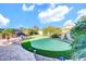 Well maintained backyard with a putting green, mature landscape, and hardscape, perfect for outdoor living at 42318 W Abbey Rd, Maricopa, AZ 85138
