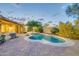 Serene backyard with a pool, spa, and lush landscaping, perfect for relaxation at 42318 W Abbey Rd, Maricopa, AZ 85138
