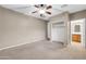Bedroom features a ceiling fan, adjacent walk-in closet, and ensuite bathroom at 42318 W Abbey Rd, Maricopa, AZ 85138