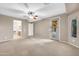 Spacious bedroom featuring neutral tones, a ceiling fan, and a private doorway to the outdoor patio at 42318 W Abbey Rd, Maricopa, AZ 85138