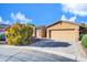 Inviting one-story home boasts a two-car garage, long driveway, and carefully maintained desert landscaping at 42318 W Abbey Rd, Maricopa, AZ 85138