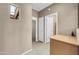 Hallway featuring a small window, neutral paint, and doors leading to different rooms at 42318 W Abbey Rd, Maricopa, AZ 85138