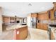 Modern kitchen features a large granite island, stainless steel appliances, and wood cabinetry at 42318 W Abbey Rd, Maricopa, AZ 85138