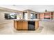 Kitchen island with bar seating, sink, and tile floors, next to an open-concept living space at 42318 W Abbey Rd, Maricopa, AZ 85138