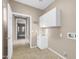 Bright laundry room equipped with a utility sink, white cabinets, and tiled floors at 42318 W Abbey Rd, Maricopa, AZ 85138