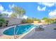 Backyard oasis features a freeform pool, lush landscaping, and a paver deck for relaxation at 42318 W Abbey Rd, Maricopa, AZ 85138