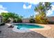 Sparkling pool in a private backyard with desert landscaping and paver patio for relaxation and enjoyment at 42318 W Abbey Rd, Maricopa, AZ 85138