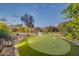 Beautiful backyard features a custom putting green and an outdoor bar area at 42318 W Abbey Rd, Maricopa, AZ 85138