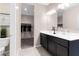 Bright bathroom featuring a double sink vanity, decorative accents, and an open doorway to the walk-in closet at 5106 E Midnight Star Dr, San Tan Valley, AZ 85143