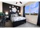 Stylishly decorated bedroom with a black accent wall, floral accents, and a large window with ample natural light at 5106 E Midnight Star Dr, San Tan Valley, AZ 85143