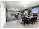 An open-concept dining area with a table set, seamlessly connected to the living area with sliding glass doors at 5106 E Midnight Star Dr, San Tan Valley, AZ 85143