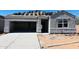 Unfinished gray home featuring an attached two-car garage, covered porch, and stacked roof tiles at 5106 E Midnight Star Dr, San Tan Valley, AZ 85143