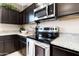 Close-up of stainless steel oven and stovetop with granite countertops and ample dark wood cabinetry at 5106 E Midnight Star Dr, San Tan Valley, AZ 85143