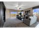 Spacious living room featuring a comfortable sectional sofa, large windows, and sliding glass doors to the yard at 5106 E Midnight Star Dr, San Tan Valley, AZ 85143