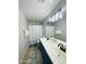 Bright bathroom featuring double sinks, blue vanity, decorative shower curtain, and modern lighting at 7136 N 73Rd Dr, Glendale, AZ 85303