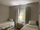 Well-lit bedroom featuring two twin beds and a stylish nightstand next to a window with curtains at 7136 N 73Rd Dr, Glendale, AZ 85303