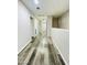 Hallway with wood flooring, white walls, and access to multiple rooms at 7136 N 73Rd Dr, Glendale, AZ 85303