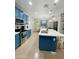 Bright, open kitchen with blue cabinetry, stainless appliances, island and dining area at 7136 N 73Rd Dr, Glendale, AZ 85303
