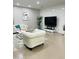 Modern living room with a comfortable white armchair, TV, and stylish decor, perfect for relaxing at 7136 N 73Rd Dr, Glendale, AZ 85303