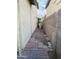Narrow side yard between two houses with brick and gravel ground cover at 7136 N 73Rd Dr, Glendale, AZ 85303