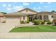 Beautiful single-story home featuring a two-car garage, lush lawn, and stone accents at 8046 W Yukon Dr, Peoria, AZ 85382