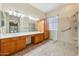 Spacious main bathroom with dual sinks, glass shower, and tile flooring at 8046 W Yukon Dr, Peoria, AZ 85382