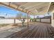 A covered patio with a wooden deck overlooks the spacious backyard with a tree and partial privacy wall at 946 S Pomeroy Cir, Mesa, AZ 85210