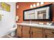 Bathroom featuring a single sink vanity, toilet, and large framed mirror reflecting a shower at 10030 W Indian School Rd # 221, Phoenix, AZ 85037