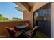 Balcony with outdoor seating, a table, and views of lush greenery at 10030 W Indian School Rd # 221, Phoenix, AZ 85037