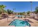 Community pool featuring a spa, lounge chairs, and mature palm trees for shade at 10030 W Indian School Rd # 221, Phoenix, AZ 85037