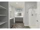 Well-lit bathroom featuring a gray vanity, mirror, walk-in shower, and stylish gray herringbone floors at 1056 N Miller Rd, Tempe, AZ 85288