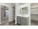 Well-lit bathroom featuring a gray vanity, mirror, closet, and stylish gray herringbone floors at 1056 N Miller Rd, Tempe, AZ 85288