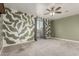 Spacious bedroom featuring custom leaf wall art, neutral carpeting, ceiling fan and sliding glass doors to the outside deck at 1056 N Miller Rd, Tempe, AZ 85288