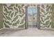 Bright bedroom featuring custom leaf wall art, neutral carpeting, and sliding glass doors to the outside deck at 1056 N Miller Rd, Tempe, AZ 85288