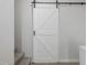 Hallway features a white barn door with black hardware and light switch at 1056 N Miller Rd, Tempe, AZ 85288