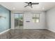 Bright living room features stylish gray herringbone floors, a ceiling fan, sliding glass door, and white trim at 1056 N Miller Rd, Tempe, AZ 85288