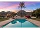 Inviting backyard pool with mountain views, a desert landscape, and an outdoor kitchen area at 11809 S Montezuma Ct, Phoenix, AZ 85044
