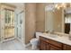 Bright bathroom featuring a tiled shower with glass doors, and a wooden vanity at 11809 S Montezuma Ct, Phoenix, AZ 85044