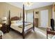 Inviting bedroom with a four-poster bed, neutral tones, plantation shutters, and cozy lighting at 11809 S Montezuma Ct, Phoenix, AZ 85044