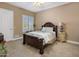 Cozy bedroom with neutral tones, plush carpeting, shutters, and a wooden bed frame at 11809 S Montezuma Ct, Phoenix, AZ 85044