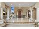 Grand foyer with marble flooring, a curved staircase, elegant columns, and a custom wooden front door at 11809 S Montezuma Ct, Phoenix, AZ 85044
