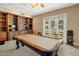 Spacious game room featuring a billiard table, custom built-ins, and patio access at 11809 S Montezuma Ct, Phoenix, AZ 85044