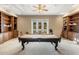 Spacious game room with custom built-in shelving, a pool table, and backyard views at 11809 S Montezuma Ct, Phoenix, AZ 85044