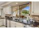 Bright kitchen features a large window with views of the patio and lush landscaping at 11809 S Montezuma Ct, Phoenix, AZ 85044